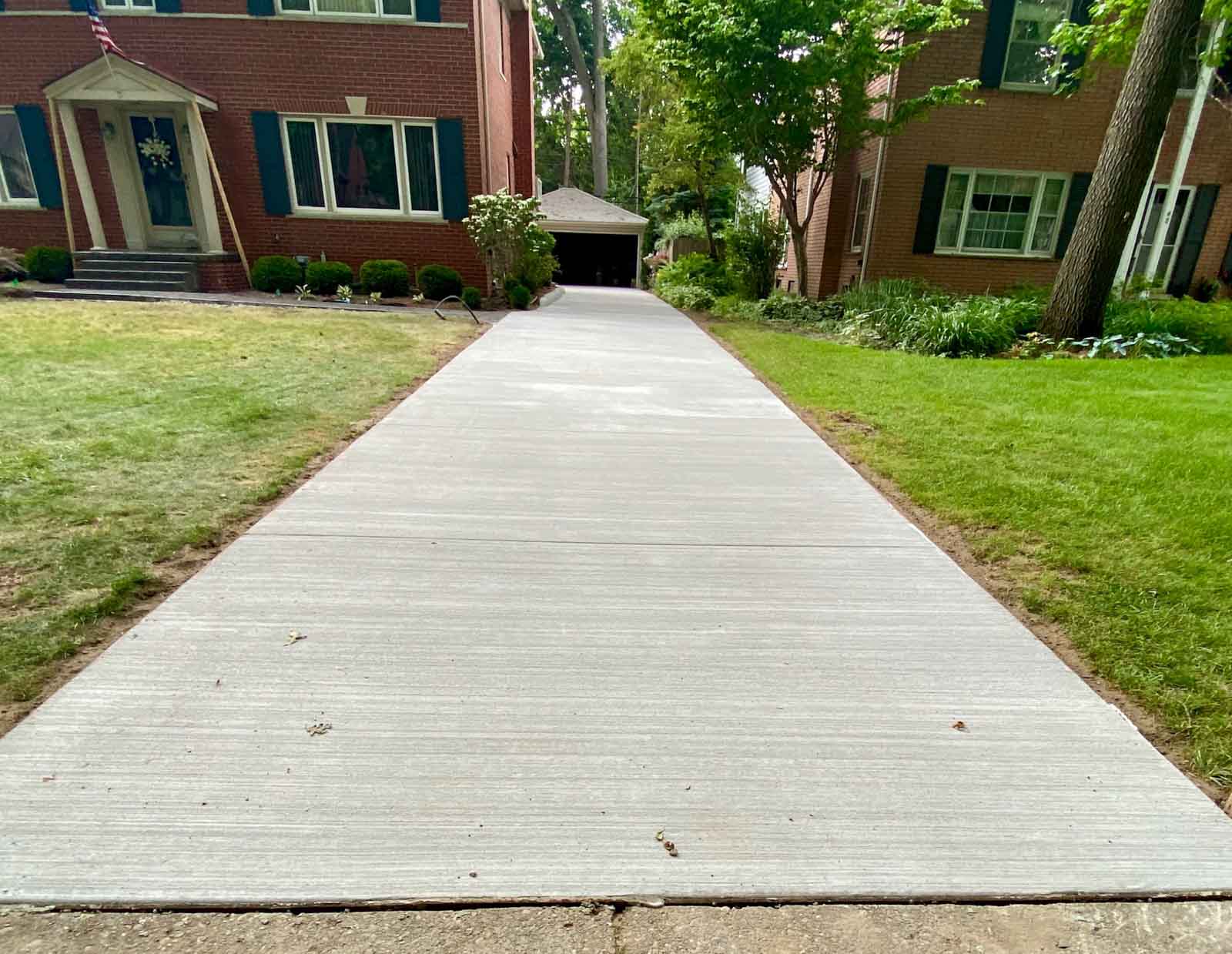 colonial house with a detached garage newly poured driveway